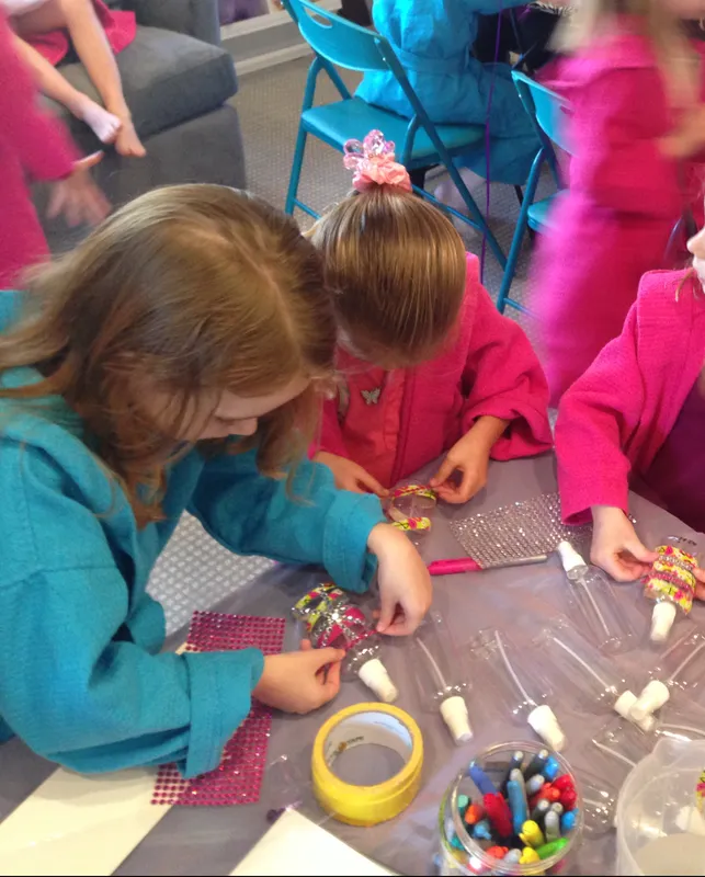 Kids in spa robes decorating body spray bottles