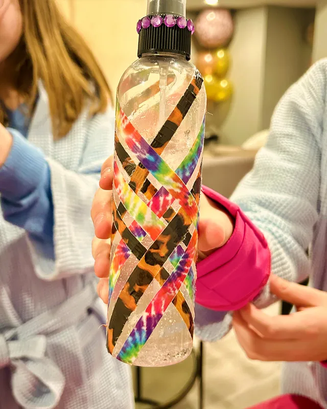 Decorated spray bottle with gems and colorful tape